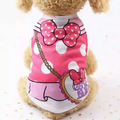 Pet dog wearing a pink cartoon vest with white polka dots, bow design, and a matching pendant, made of soft fabric for comfort